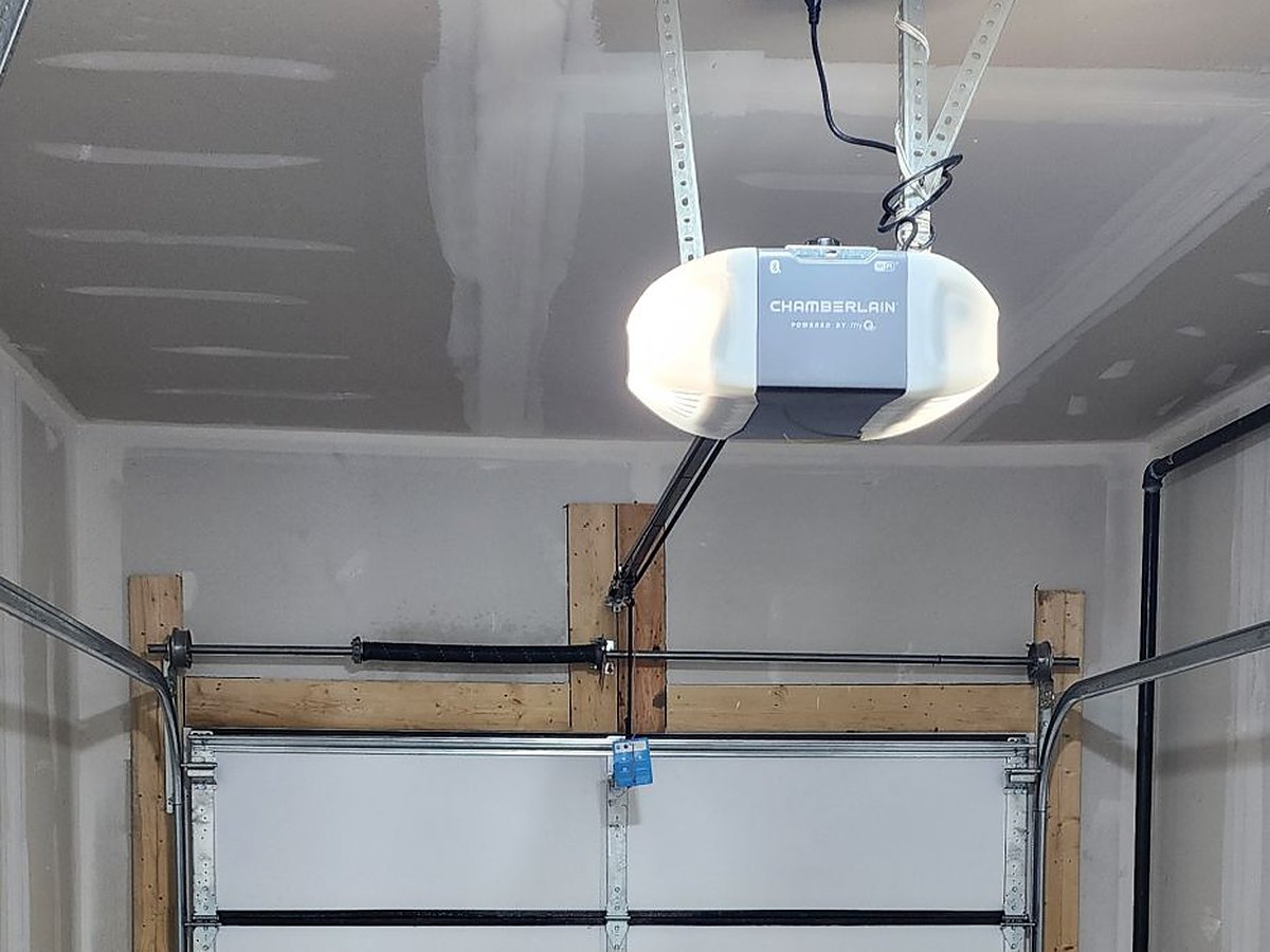 Newly fitted operator on a finished garage ceiling, the rail running forward to the door arm bolted at the top section